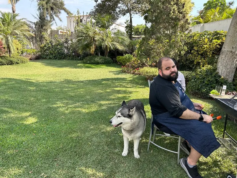 Renzo sitting in garden with his husky, December 2023